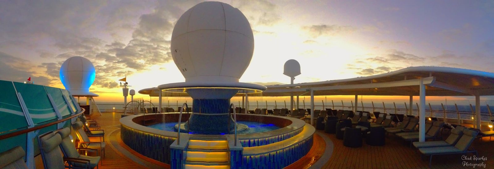 A cruise ship deck at sunset with the sea beyond
